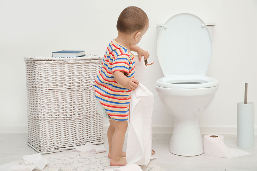 A toddler throwing toilet paper and toys into a residential toilet and creating a drain clog that requires professional plumbing assistance in Decatur, IL.