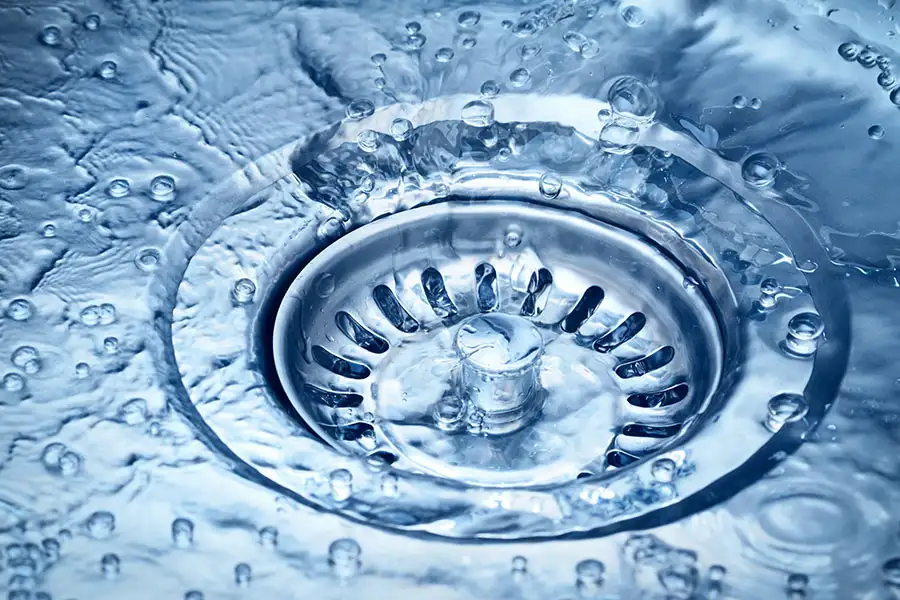 close up of water flowing down a kitchen sink drain