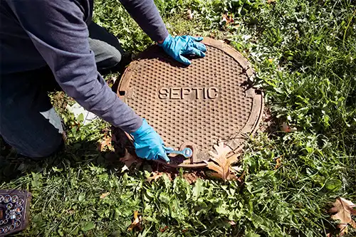 A professional from Septic Specialists wearing gloves and getting ready to inspect a septic system in Decatur, IL.