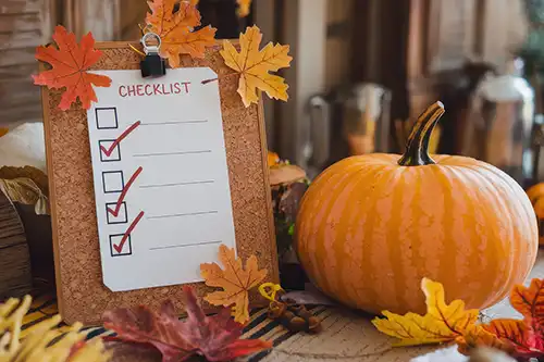 Sewer & Septic Specialist—A blank fall checklist for septic & sewer maintenance propped up next to fall leaves and a pumpkin in Decatur, IL.