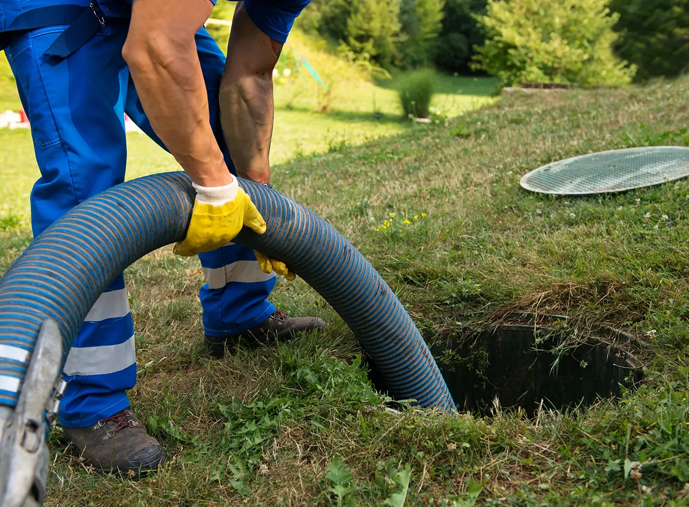 man lowering sewer cleaning equipment into a sewer line decatur il